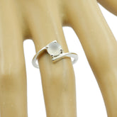 Trendy white solitaire ring with a sleek design, featured on a hand model for elegant styling
